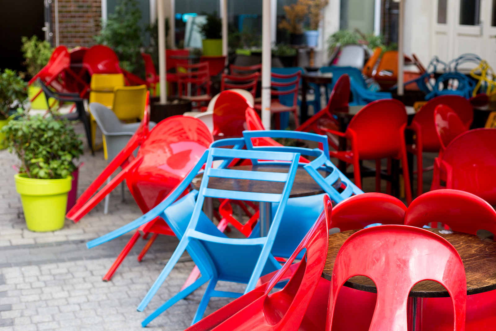 Colourful tables and chairs in a cafe. Yellow, blue, red colors. Outdoor