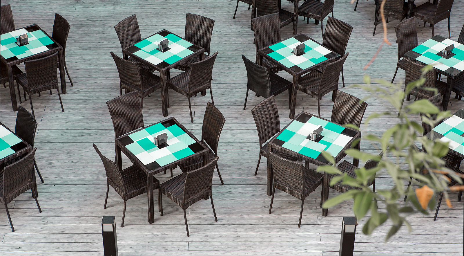 Dining tables and chairs on decking in outdoor restaurant area