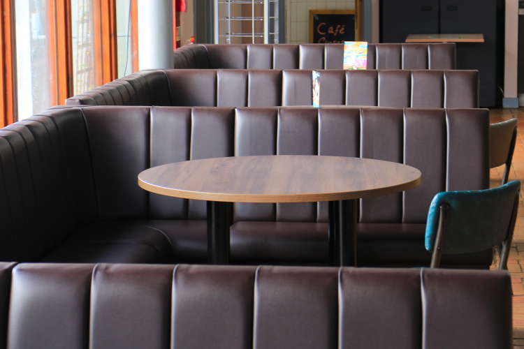 close up image of bench seating upholstery with dining table and chair.