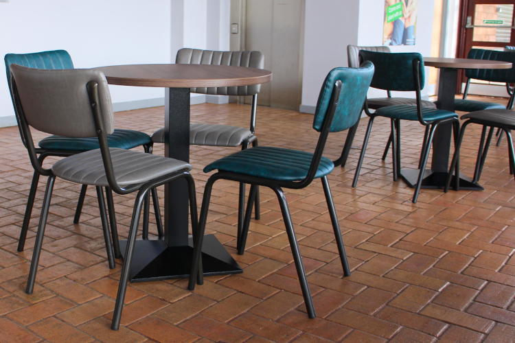 Dining chairs around a dining table in a bright cafe
