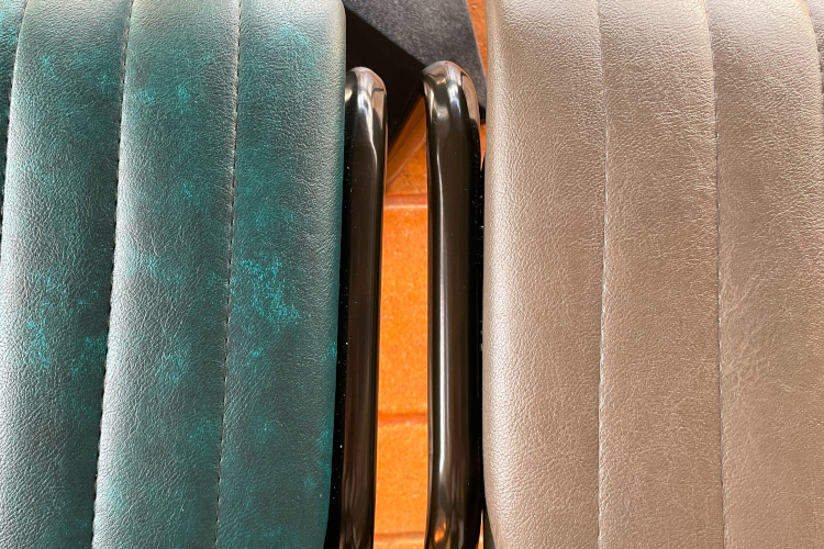 upholstery detail on quilted dining chairs with black frame.