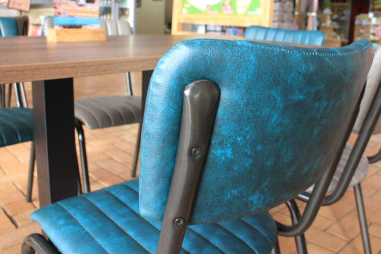 dining chair fixing detail, with teal upholstery and black frame.