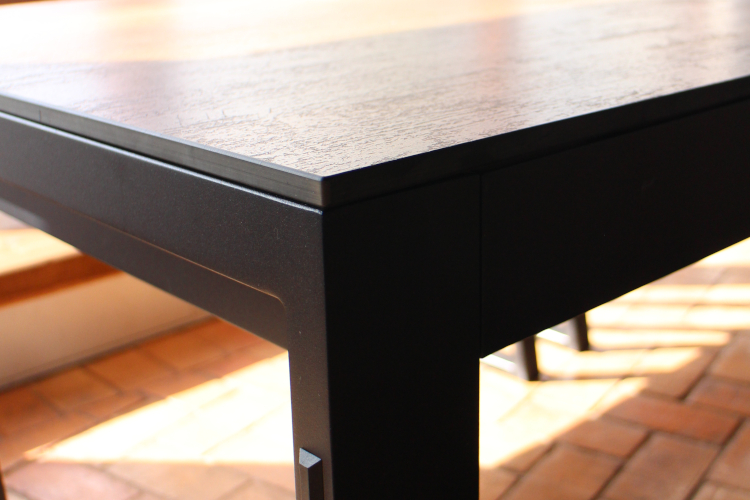 dining table close up of the black metal frame and rust effect table top