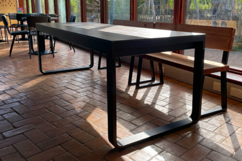 Large folding dining table with a large window behind.