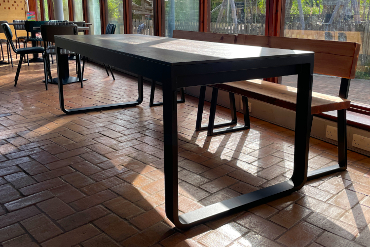 Large folding dining table with a large window behind.