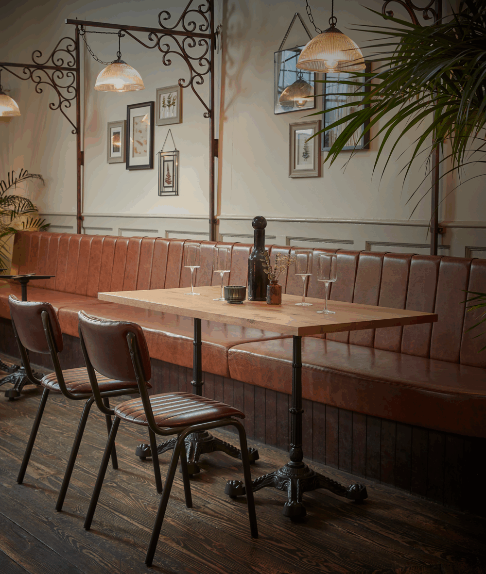 chateau rectangle dining table bases with wooden table top paired with a banquette seat on one side and two dining chairs on the other.