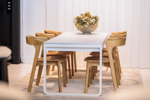 switch folding dining table with a white frame and white marble laminate table top paired with the Nina oak stacking dining chair