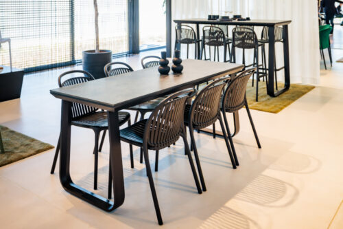 SALT folding all weather dining table in black with black moon effect HPL table top paired with side chairs in Black.