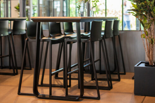 Salt folding poseur table, black frame, bamboo table top at a bar, with Black Kasar bar stools.