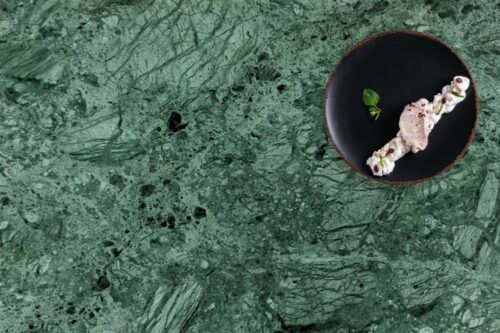 Close up of Verde Rajasthan green marble table top, with a plate of food, Birdseye view.