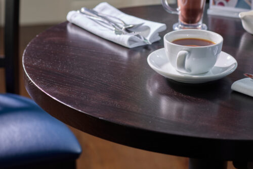 solid ash wooden table top, showing a wenge finish, with a cup of tea on the table top.