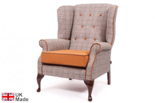 Buttoned wingback lounge armchair in a grey finsih and orange seat pad with Dark Walnut feet on a white background.