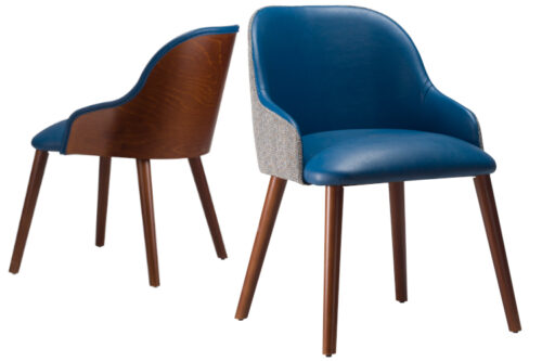 Front view of armchairs, side by side with arms. Both with blue faux leather and Walnut stained legs. One with an upholstered back, the other wooden back, both on a white background.
